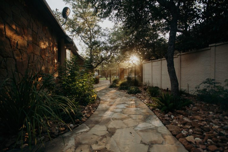 Don't waste space with this sunlit flagstone walkway bordered by lush greenery and stone accents