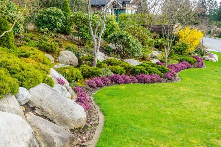 Stunning landscaped yard featuring vibrant flowers and decorative rocks, creating a serene outdoor space