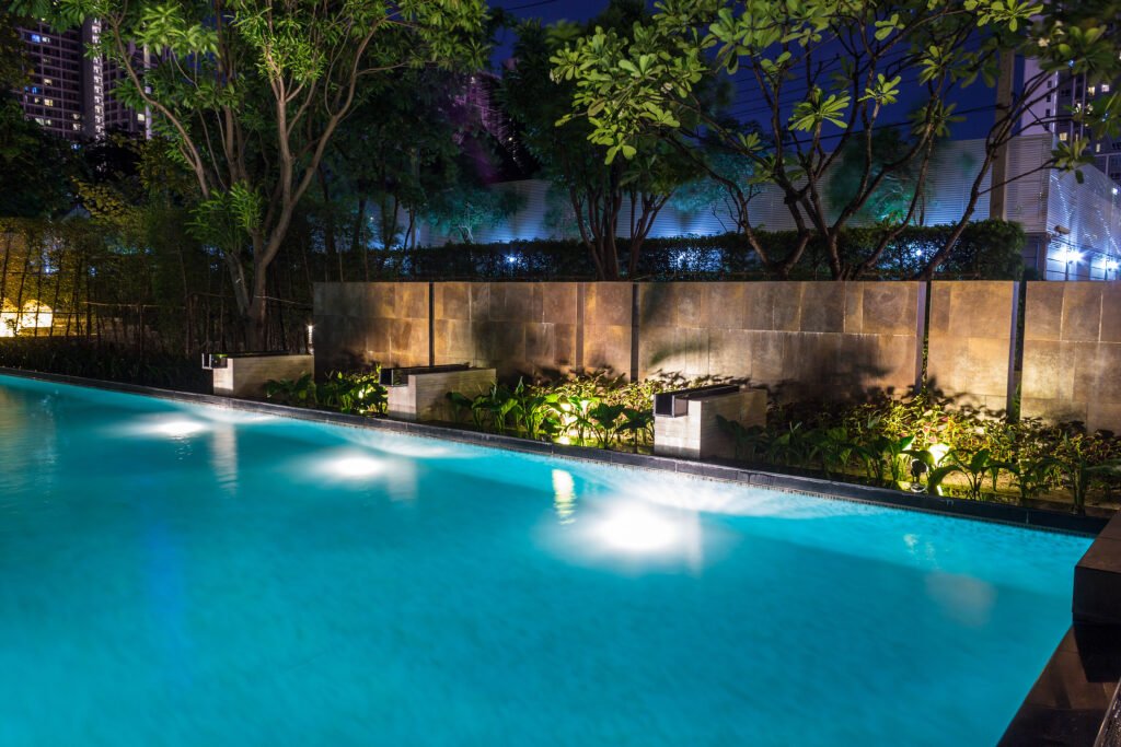 Serene night pool scene illuminated by glowing lights along the edges, creating a tranquil atmosphere