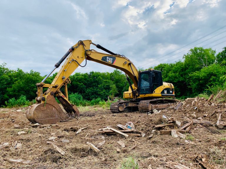 Yellow excavator is actively digging into the dirt, showcasing its powerful machinery in action