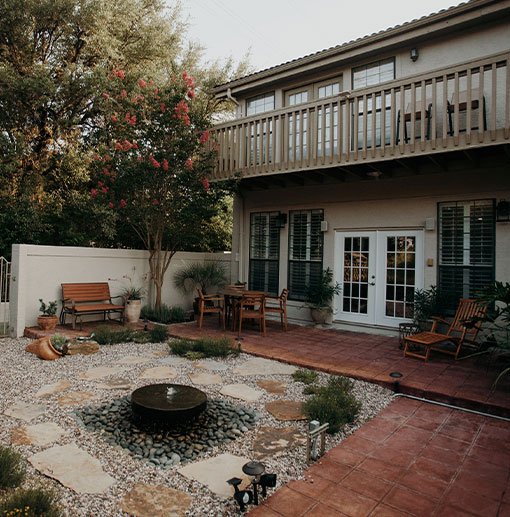 Charming backyard with hardscapes featuring a central fountain, stone pathways, and cozy seating areas