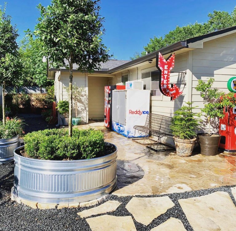 Garage featuring a metal planter with a vibrant potted plant, showcasing beautiful hardscapes