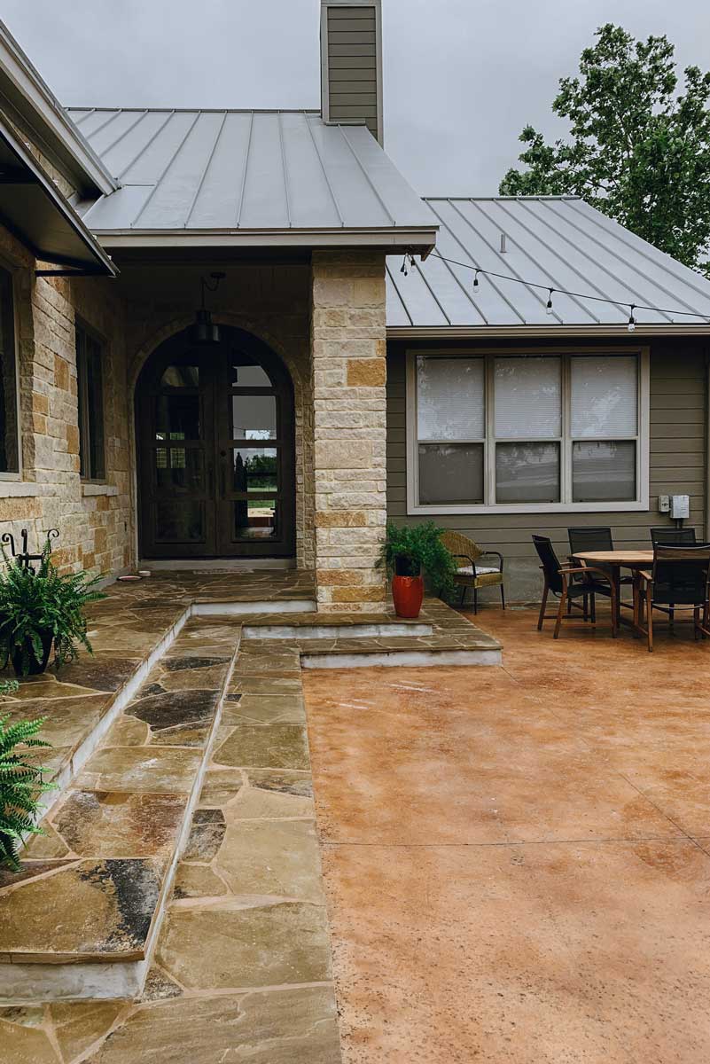 Stone patio featuring a large table and chairs, showcasing beautiful hardscapes for outdoor gatherings