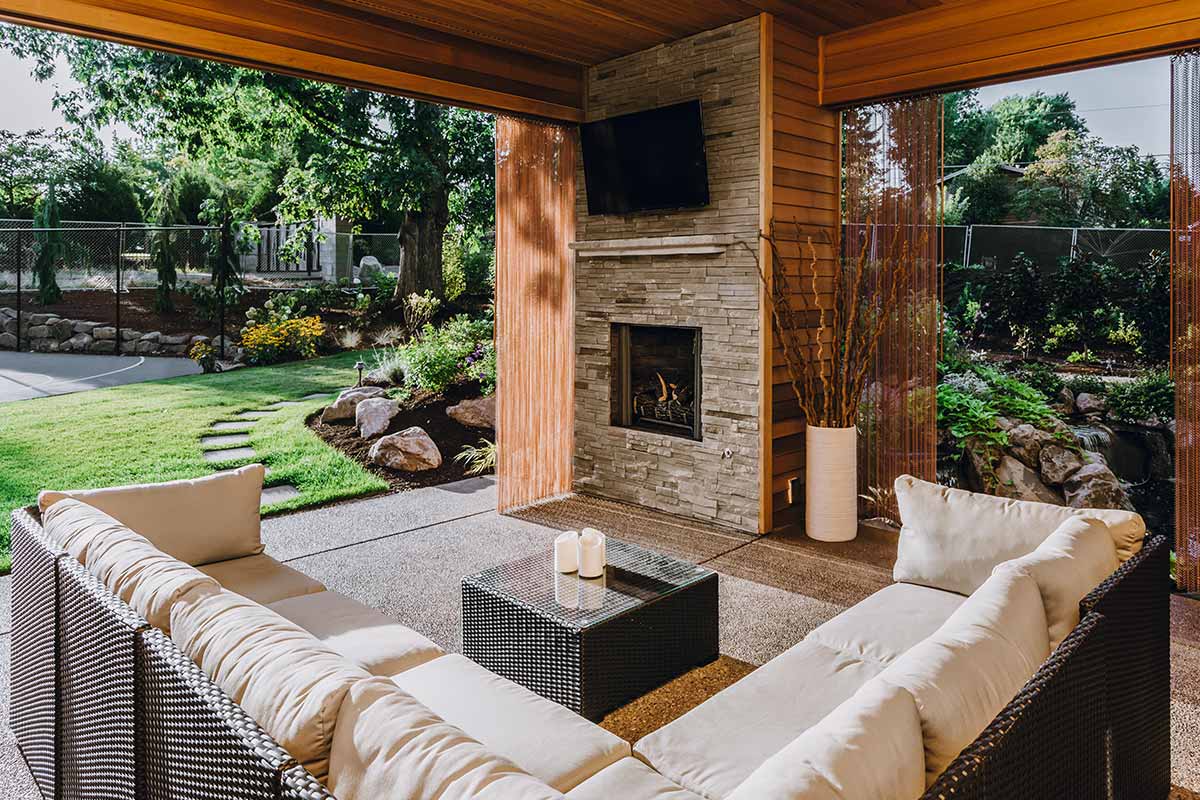 Cozy patio featuring couches and a fireplace, showcasing beautiful hardscapes for relaxation and gatherings