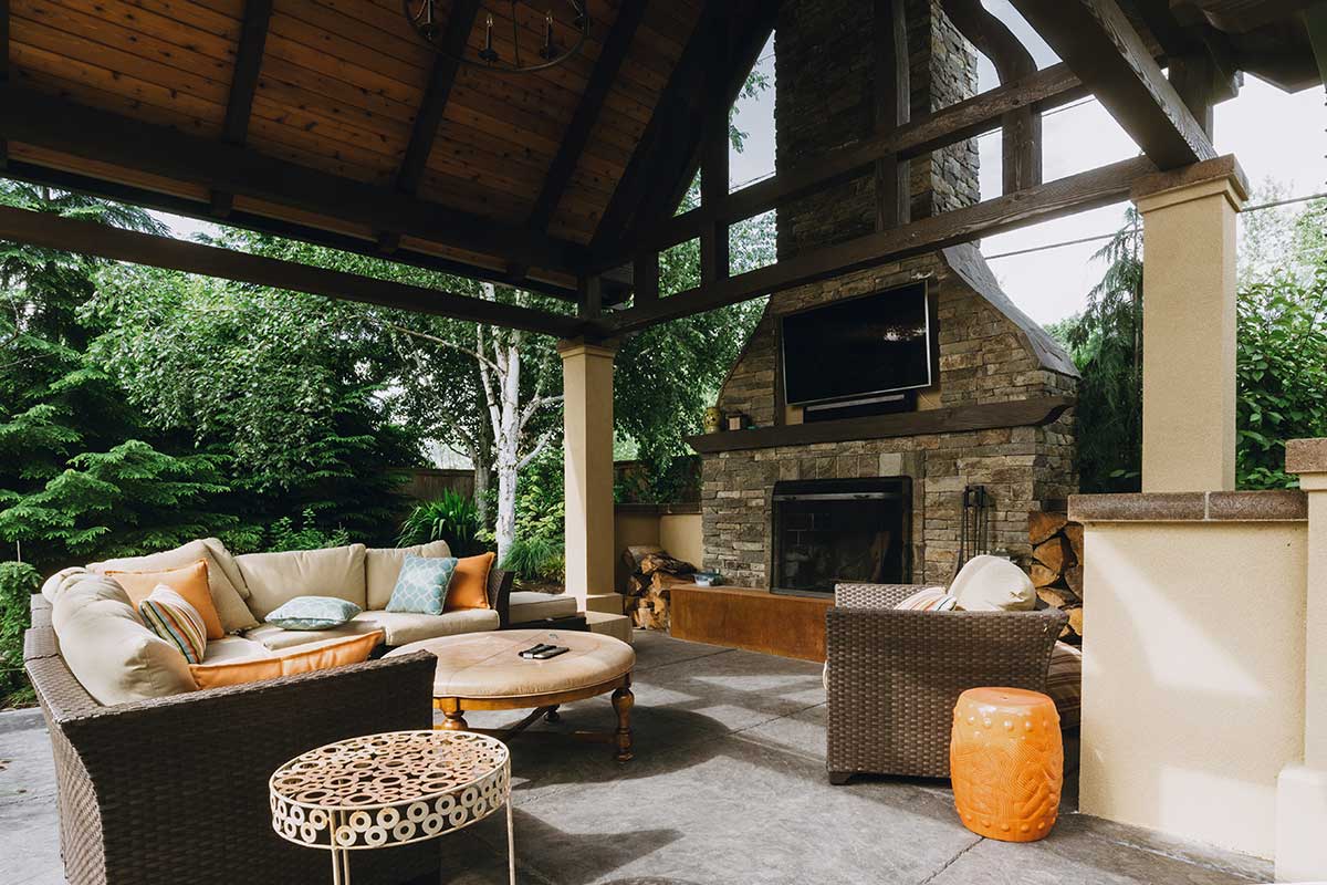 Cozy outdoor living area featuring a fireplace and wicker furniture, showcasing beautiful hardscapes for relaxation