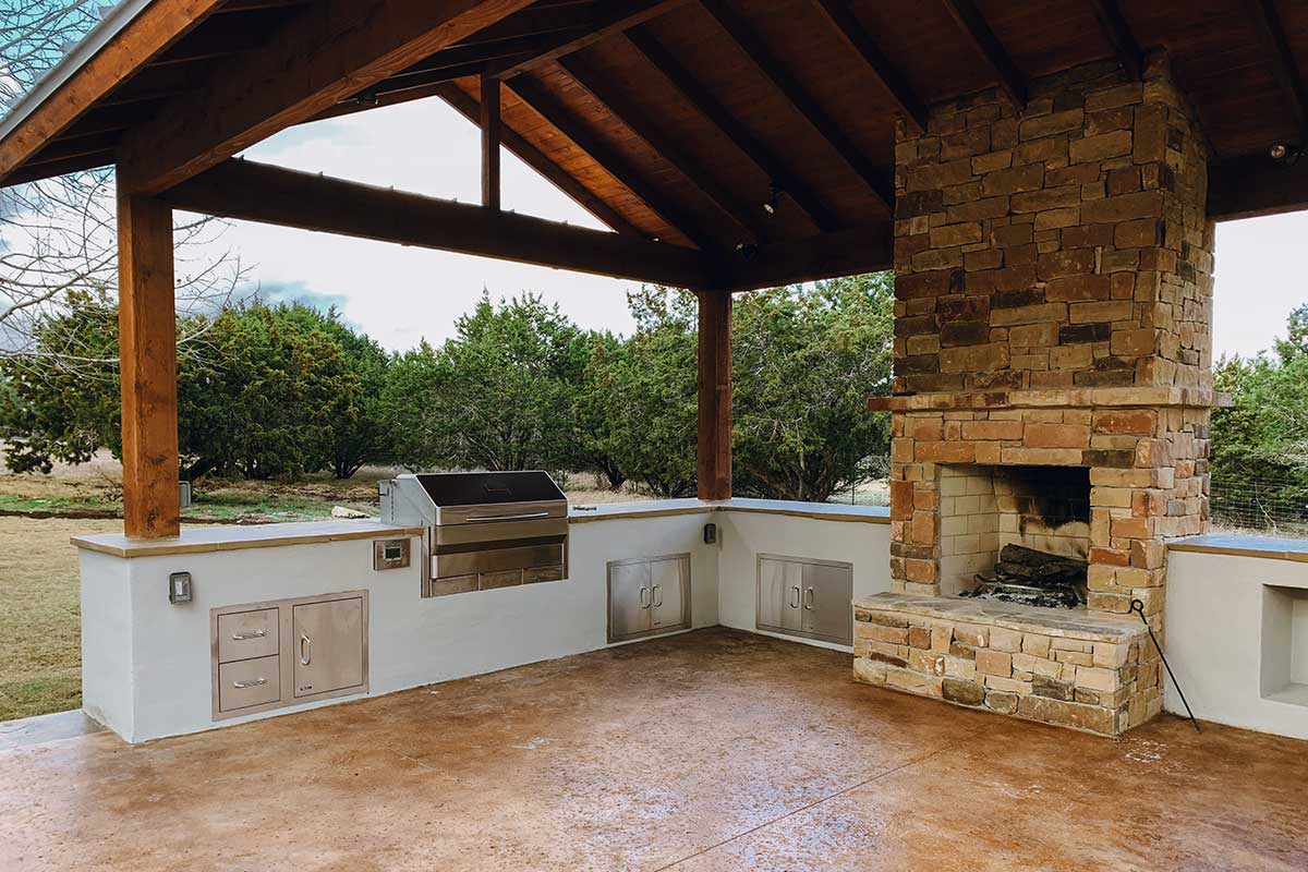 Stone fireplace in an outdoor kitchen, showcasing beautiful hardscapes for a cozy gathering space