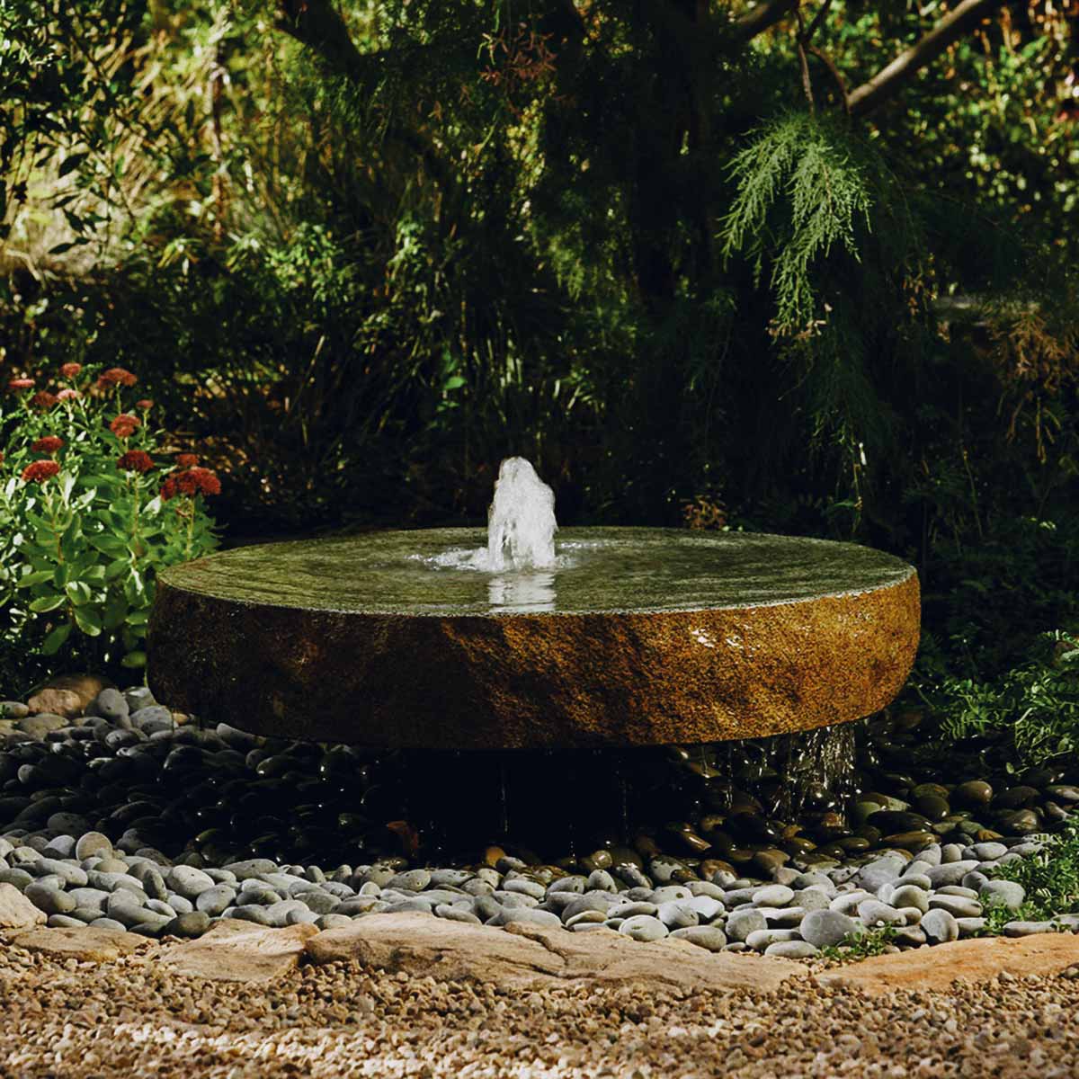 Beautiful fountain surrounded by vibrant flowers in a serene garden, showcasing stunning water features