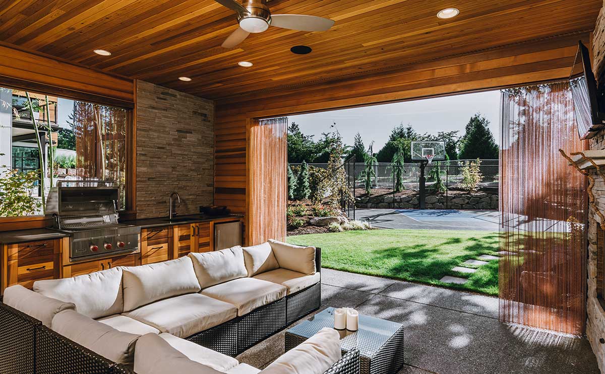 Spacious outdoor living area featuring a cozy couch and a fireplace, showcasing beautiful Hardscapes design