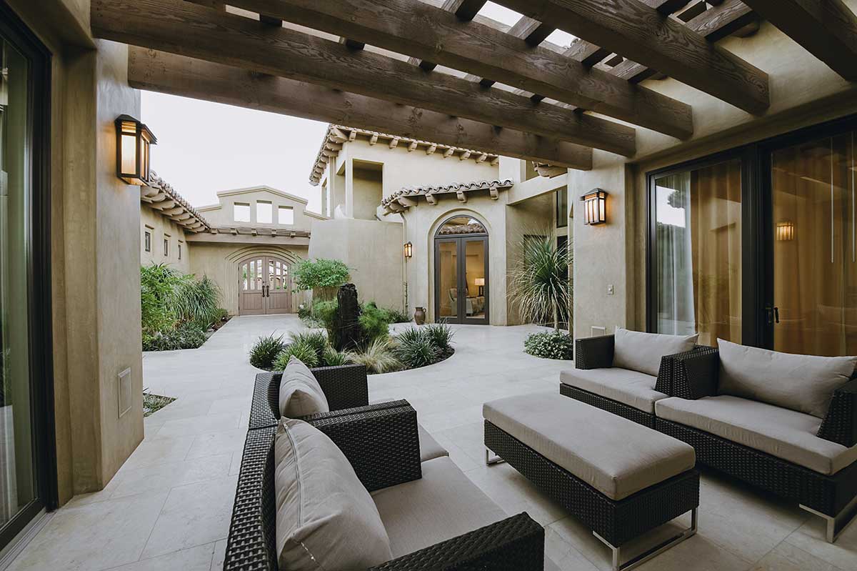 Cozy patio featuring wicker furniture and spacious outdoor living area, showcasing beautiful hardscapes