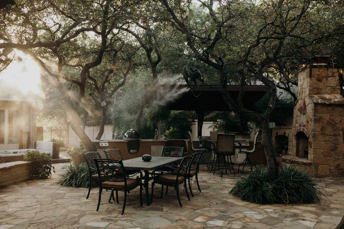 Cozy patio featuring tables and chairs nestled under trees, showcasing beautiful hardscapes for relaxation