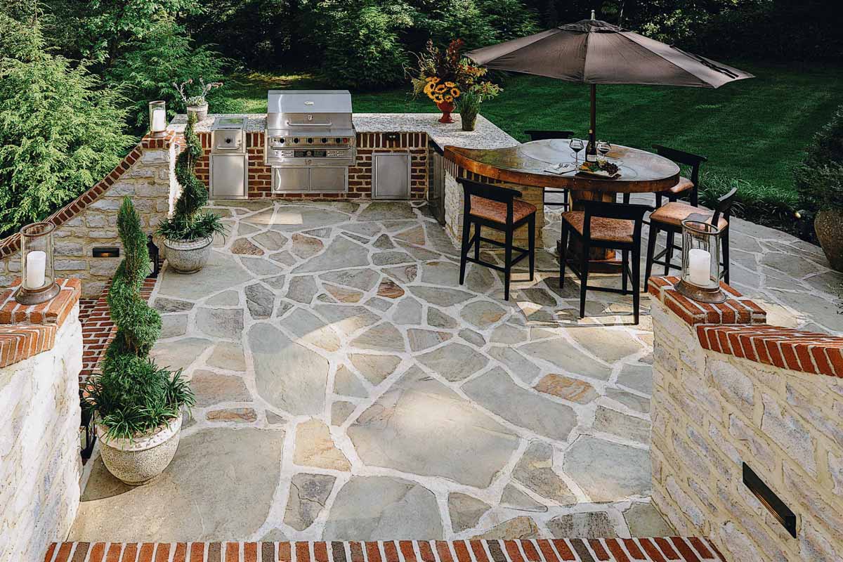 Cozy patio featuring a grill and a table, showcasing beautiful hardscapes for outdoor gatherings