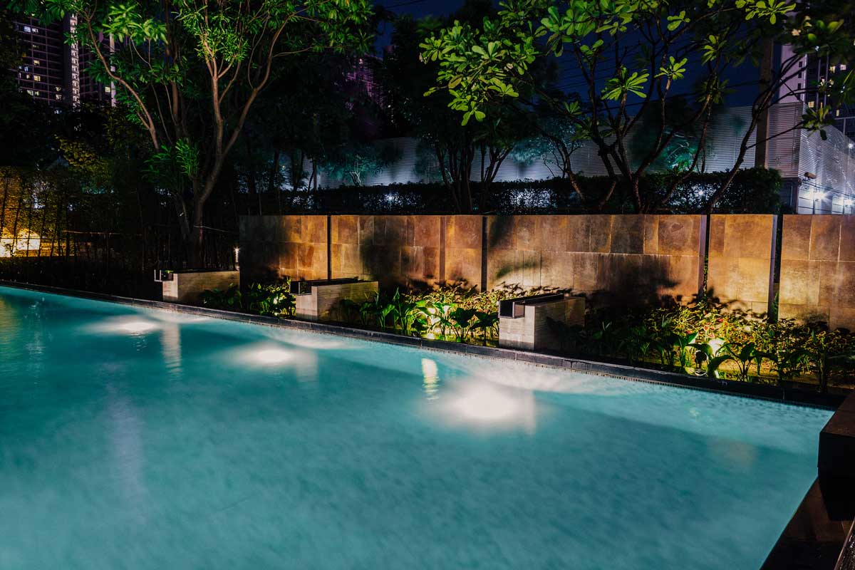 Serene night pool scene illuminated by soft lights, creating a tranquil and inviting atmosphere