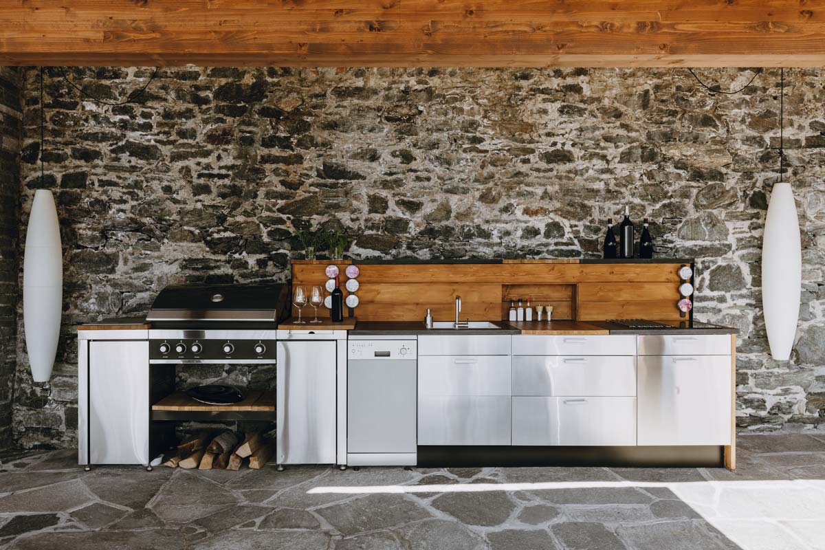 Outdoor kitchens featuring a stone wall and stove, perfect for cooking and entertaining in nature