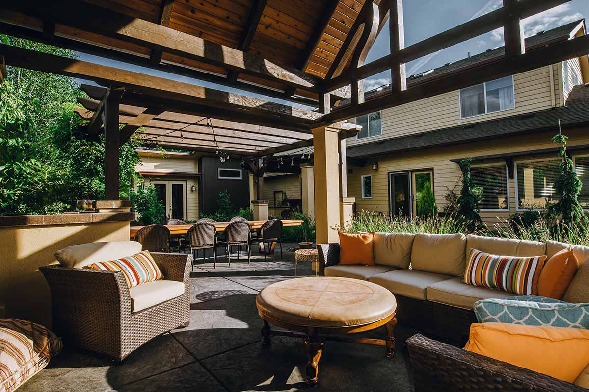 Cozy patio featuring wicker furniture under a covered area, showcasing beautiful Hardscapes design elements