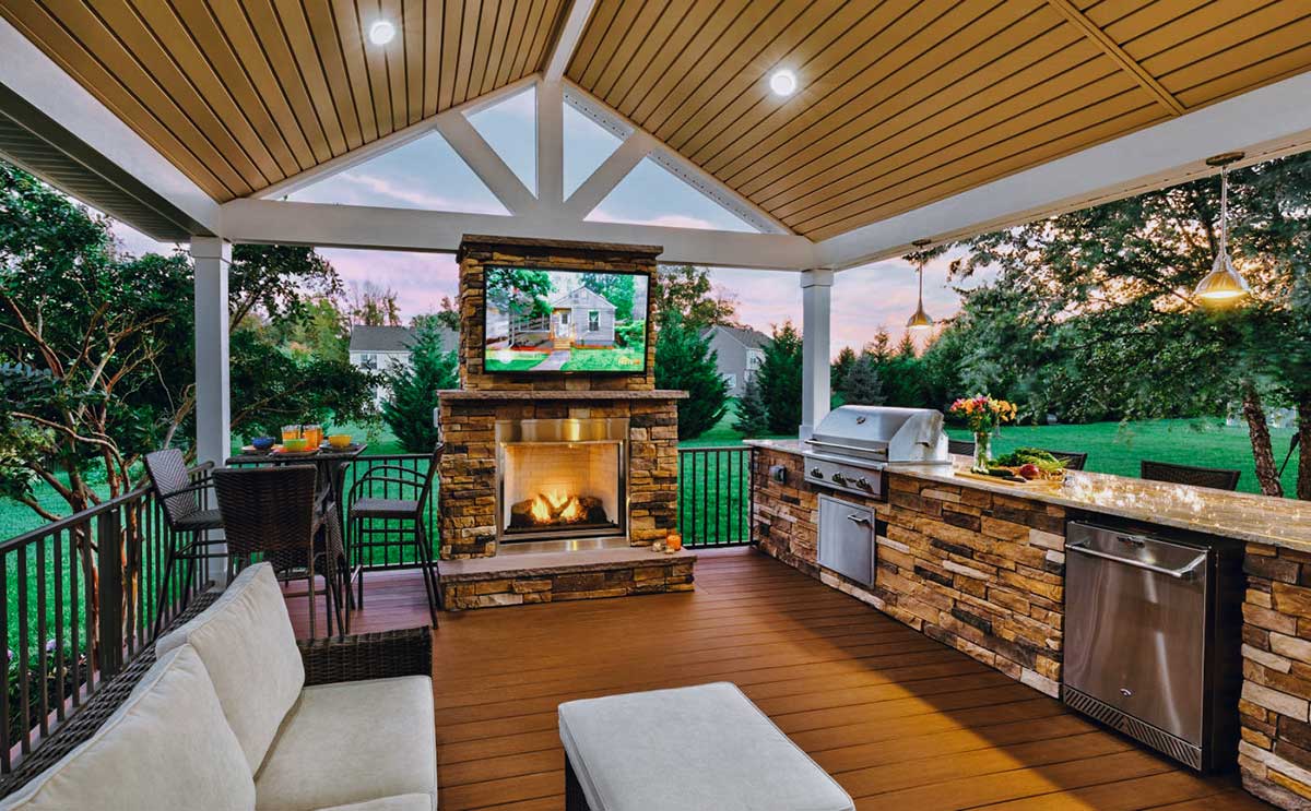 Outdoor kitchen featuring a fireplace and cozy living area, showcasing beautiful Hardscapes design elements