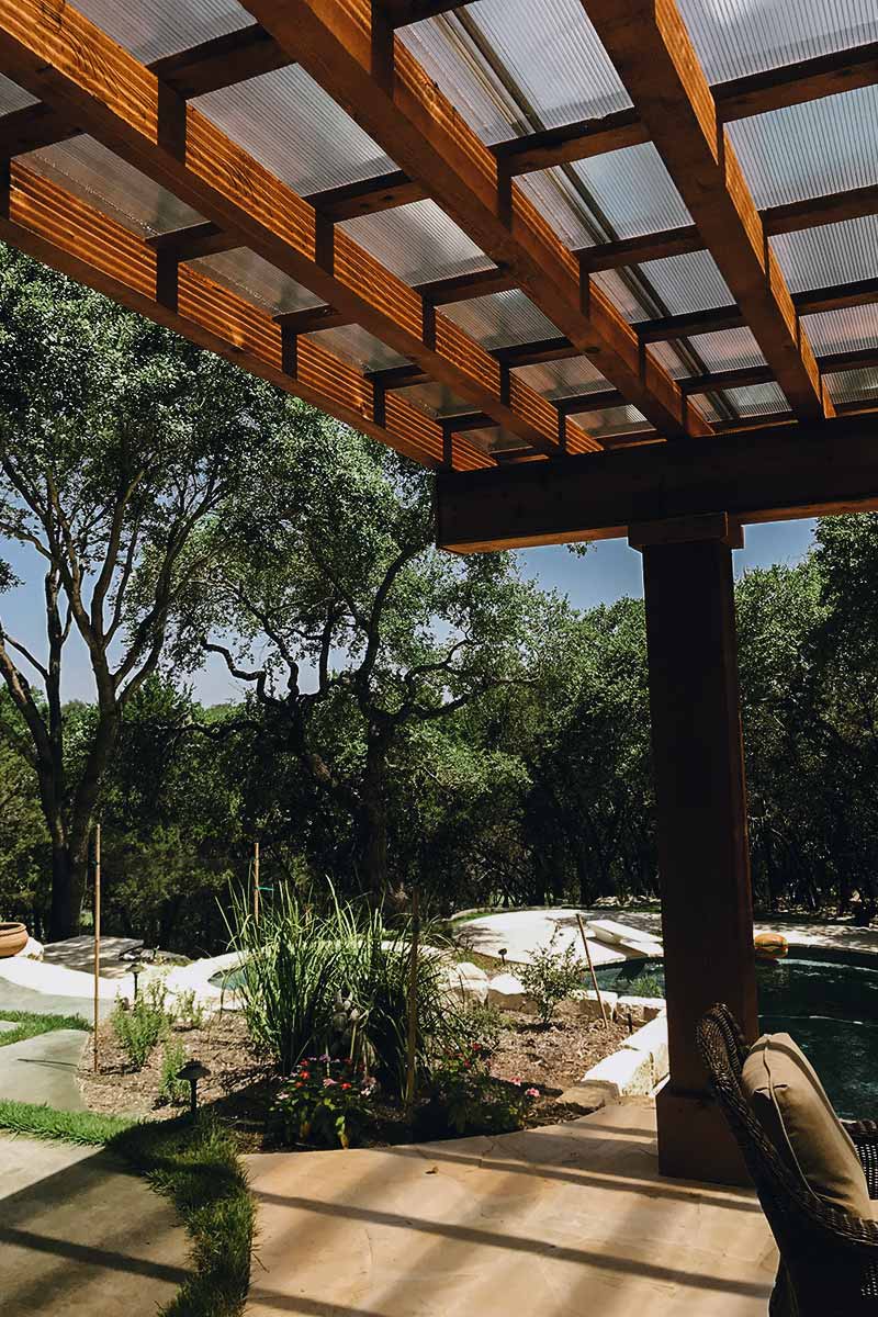 Cozy patio featuring a wooden roof and chairs, showcasing beautiful hardscapes for relaxation