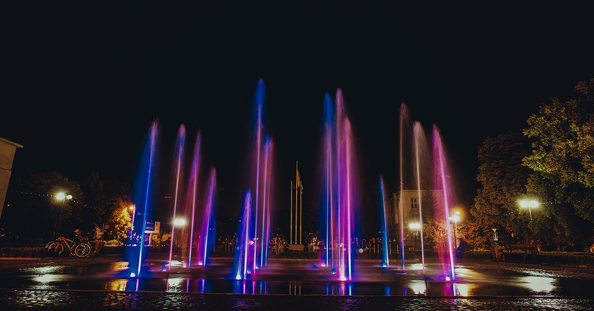 Colorful fountain at night illuminated by vibrant lights, showcasing stunning water features in a magical setting