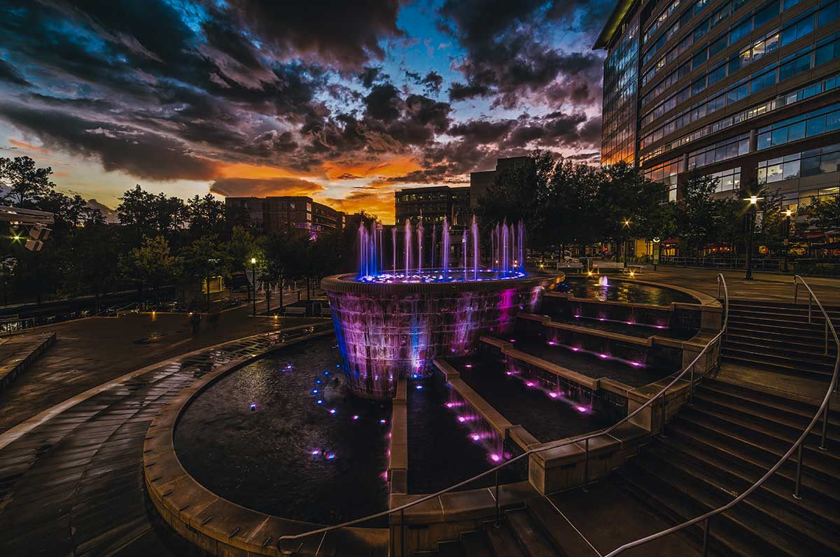 Beautiful fountain at sunset, surrounded by clouds, showcasing stunning water features in the city