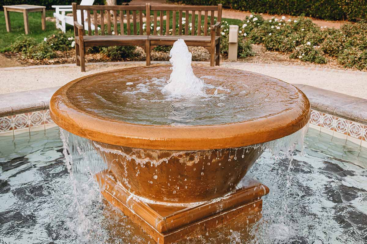 Serene garden scene featuring a fountain and a bench, showcasing beautiful water features for relaxation