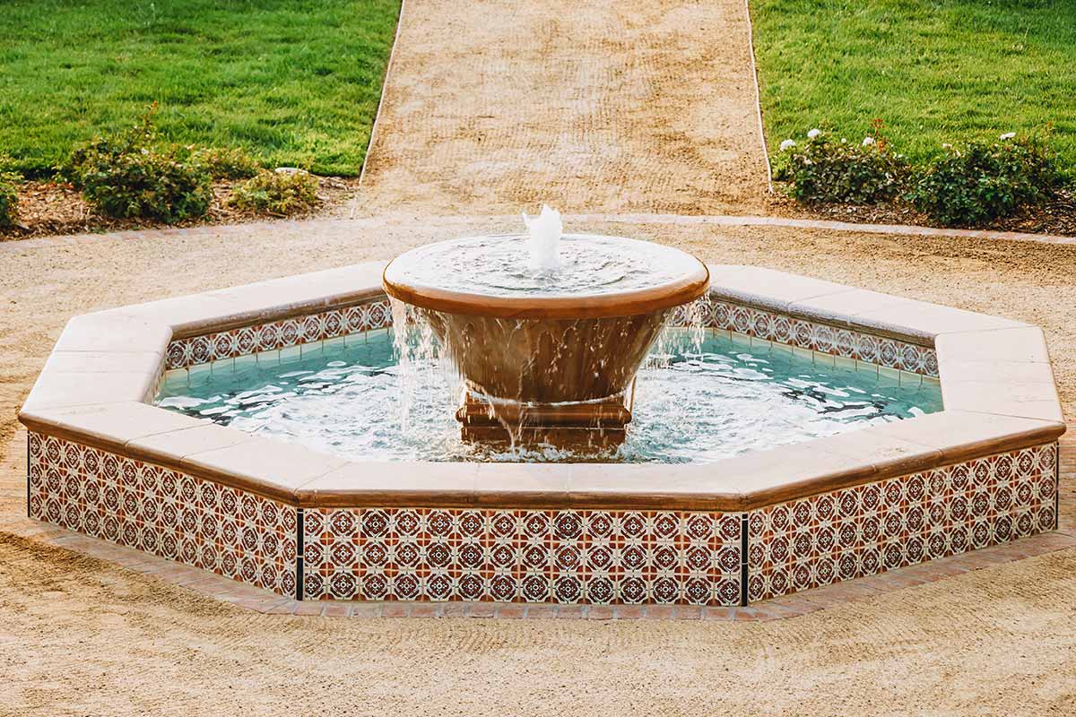 Circular fountain surrounded by lush greenery, showcasing beautiful water features in a serene garden setting