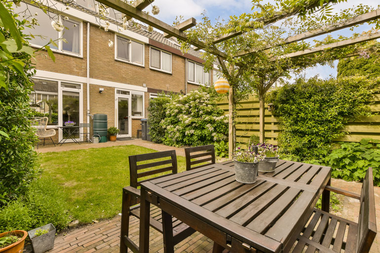 Cozy garden featuring a table and chairs set up in front of a charming house Perfect for outdoor relaxation