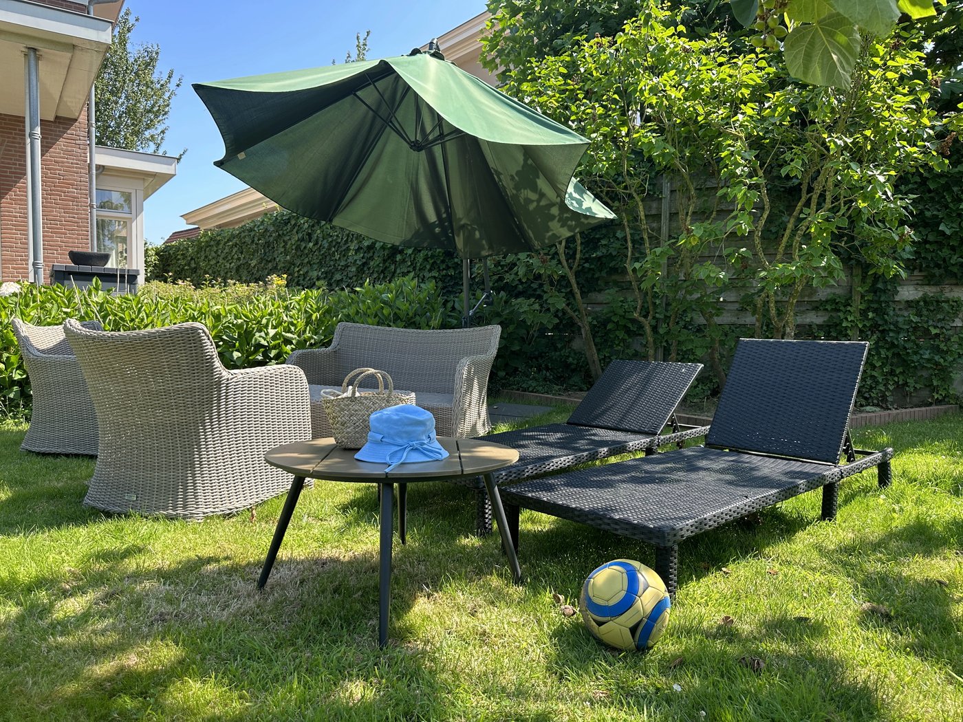 Shaded patio seating under an umbrella on a back lawn in Floresville, TX